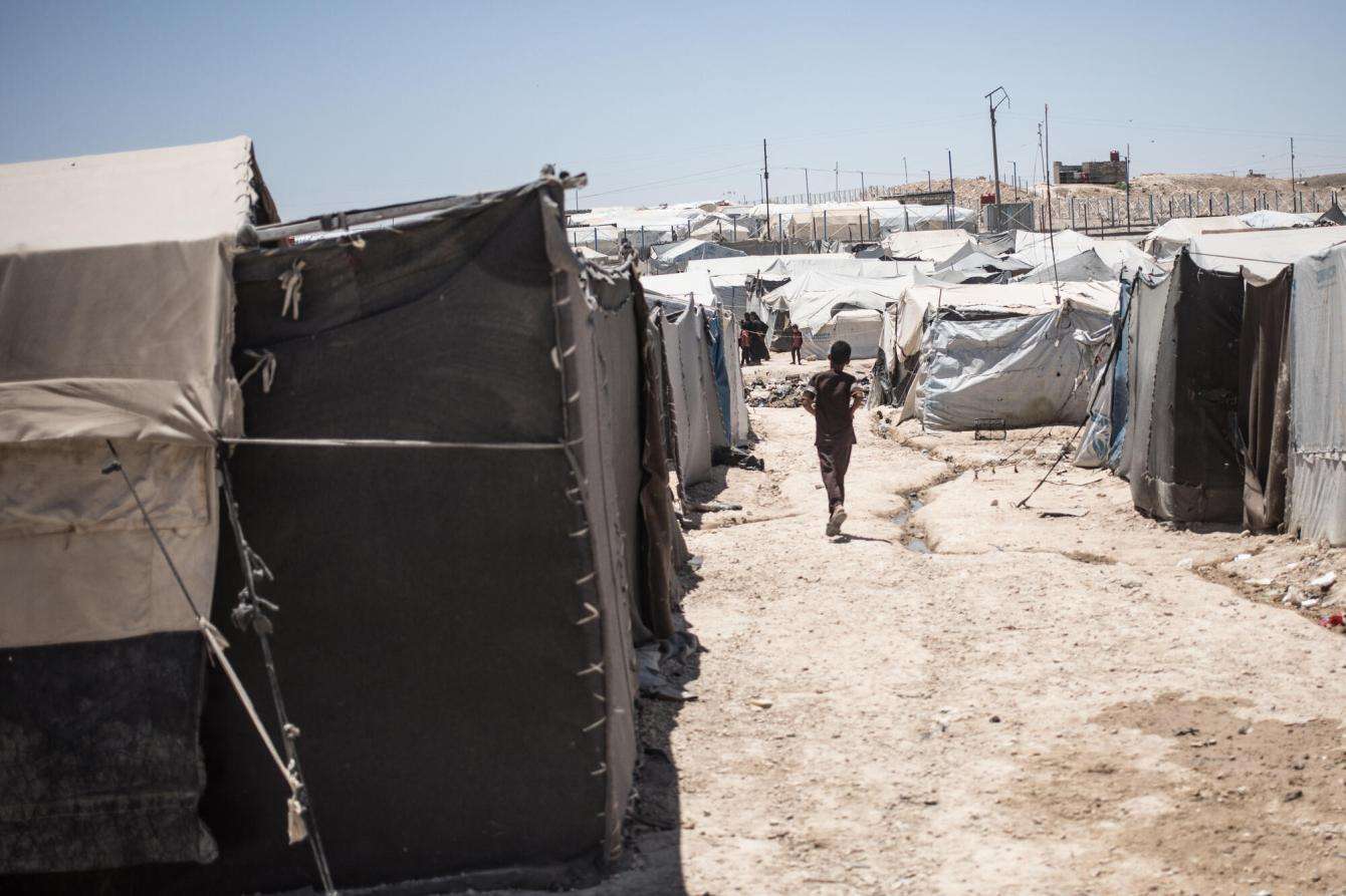 Child walking among tents in Syria.